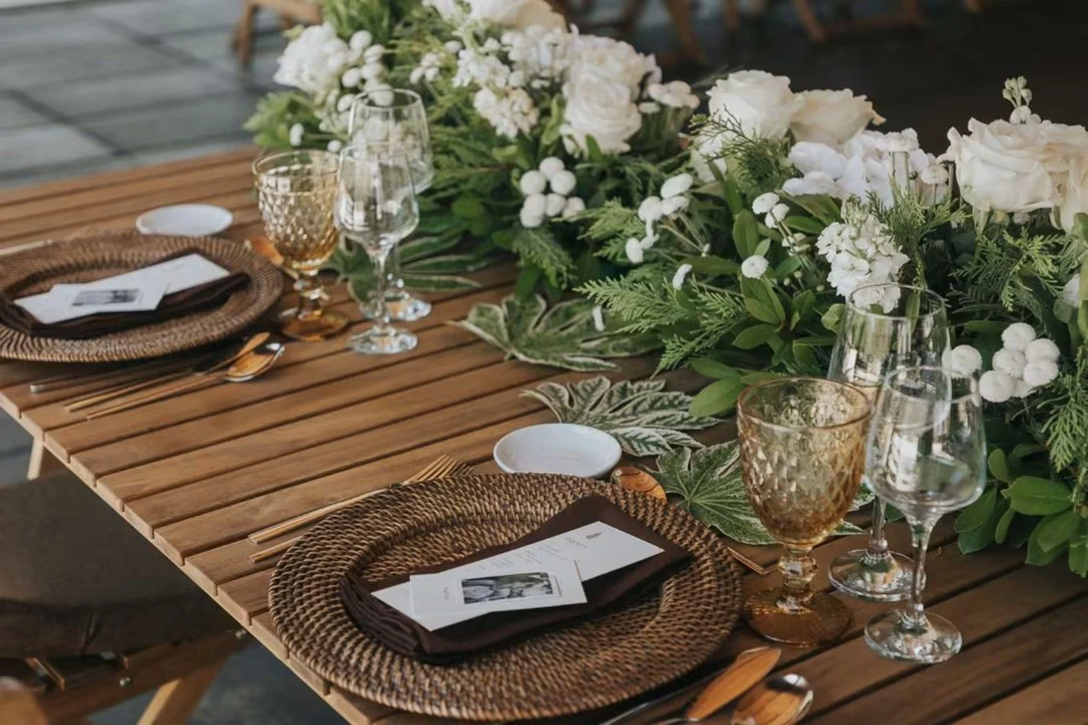 Mesa de casamento com flores brancas, madeira e copos trabalhados